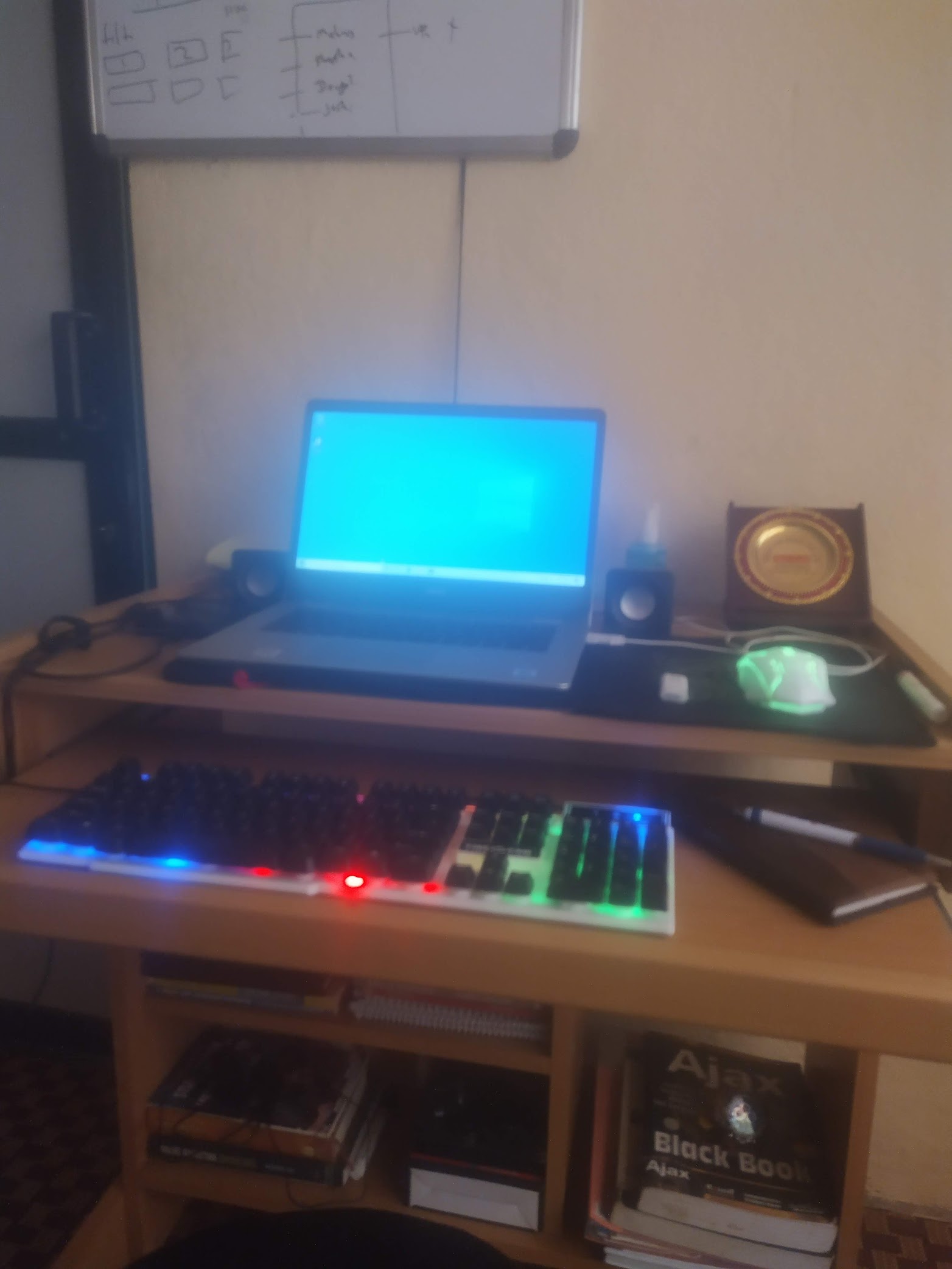 Early coding setup with a laptop, external keyboard, speakers, and whiteboard